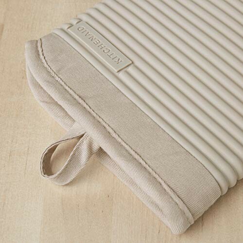 Beige ribbed oven mitt on wooden surface.