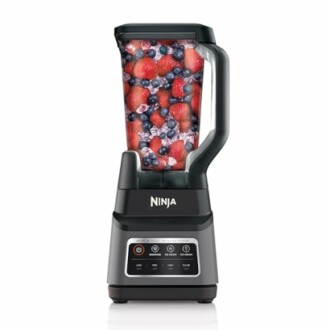 Ninja blender filled with strawberries, blueberries, and raspberries.