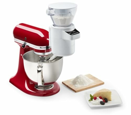 Red stand mixer with flour sifter, bowl, cake slice, and berries.